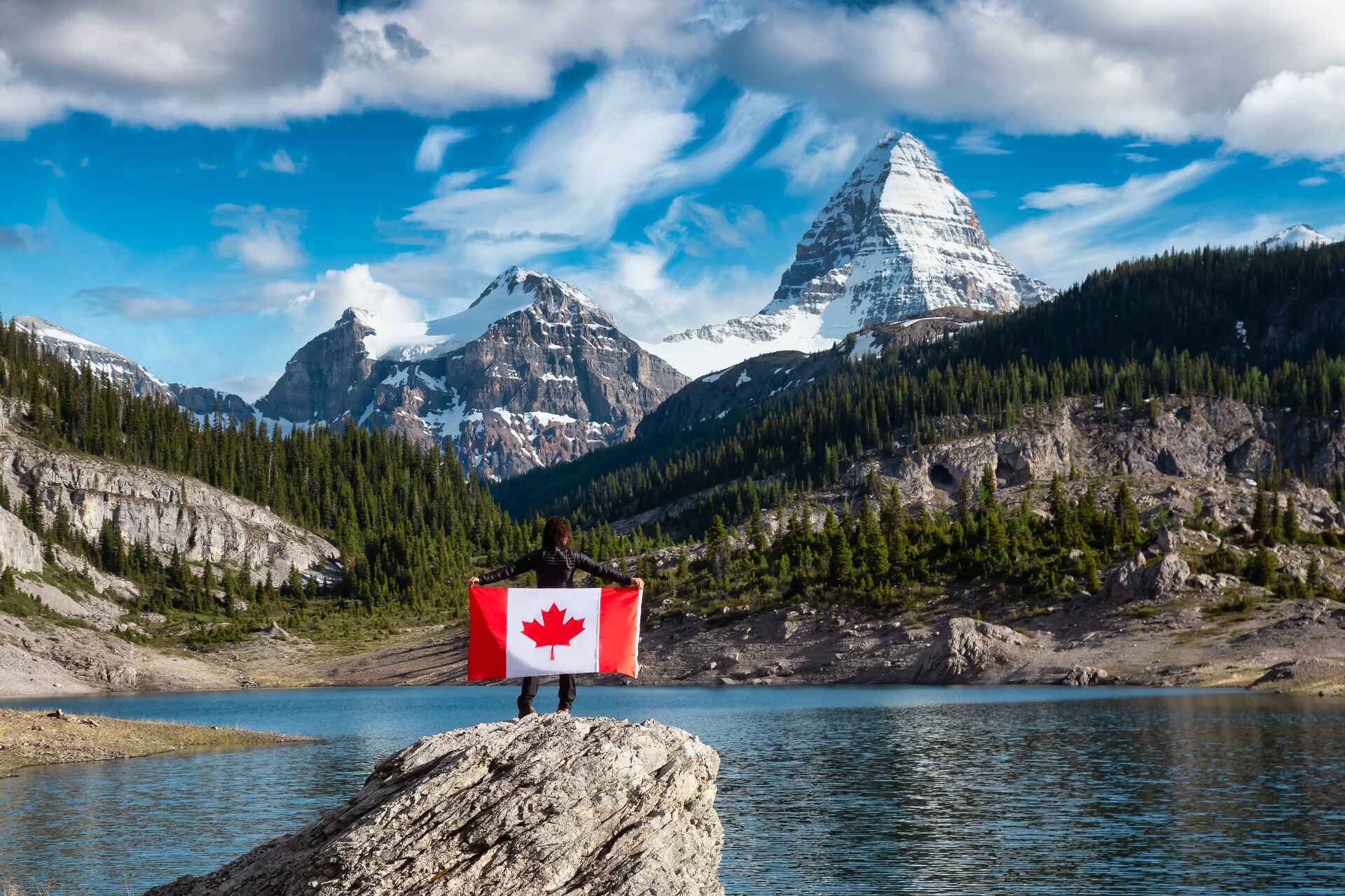 girl holding a canadian flag by the lake