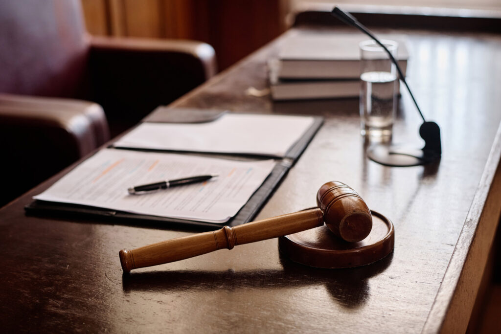 wooden gavel papers and pen on desk of judge