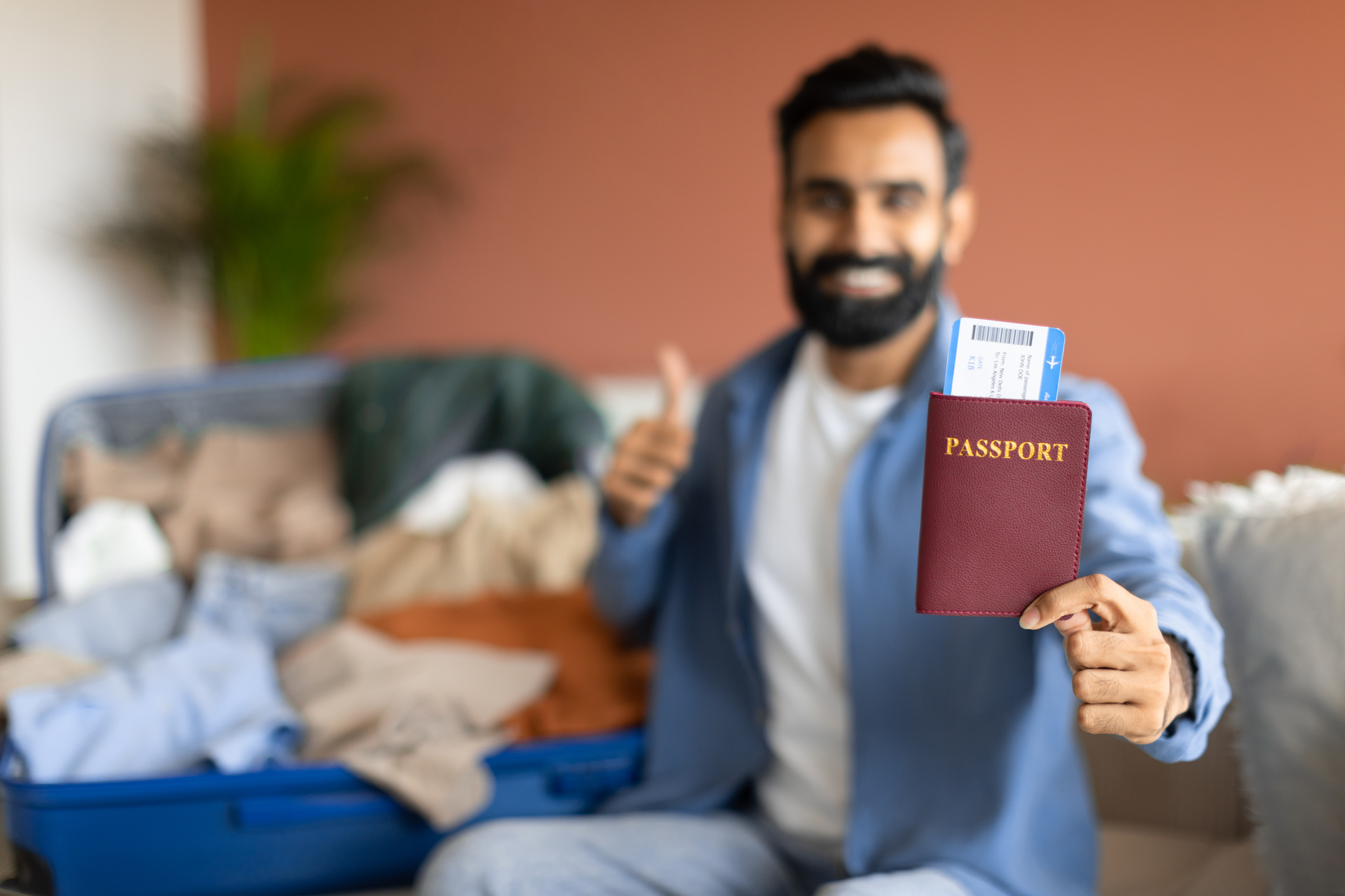 Smiling man holding passport and ticket