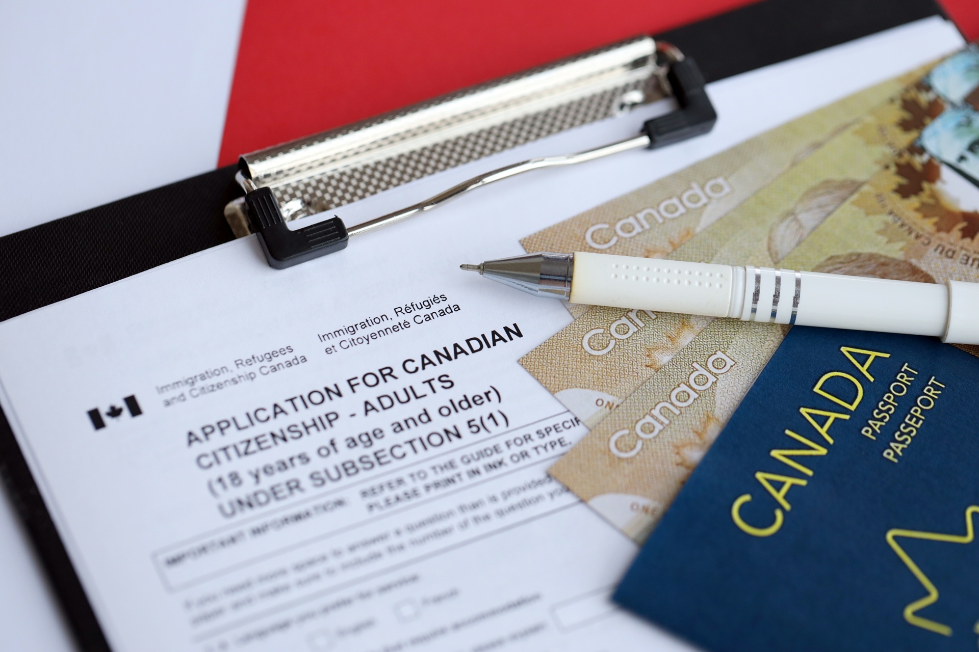 Canadian citizenship application with passport and pen