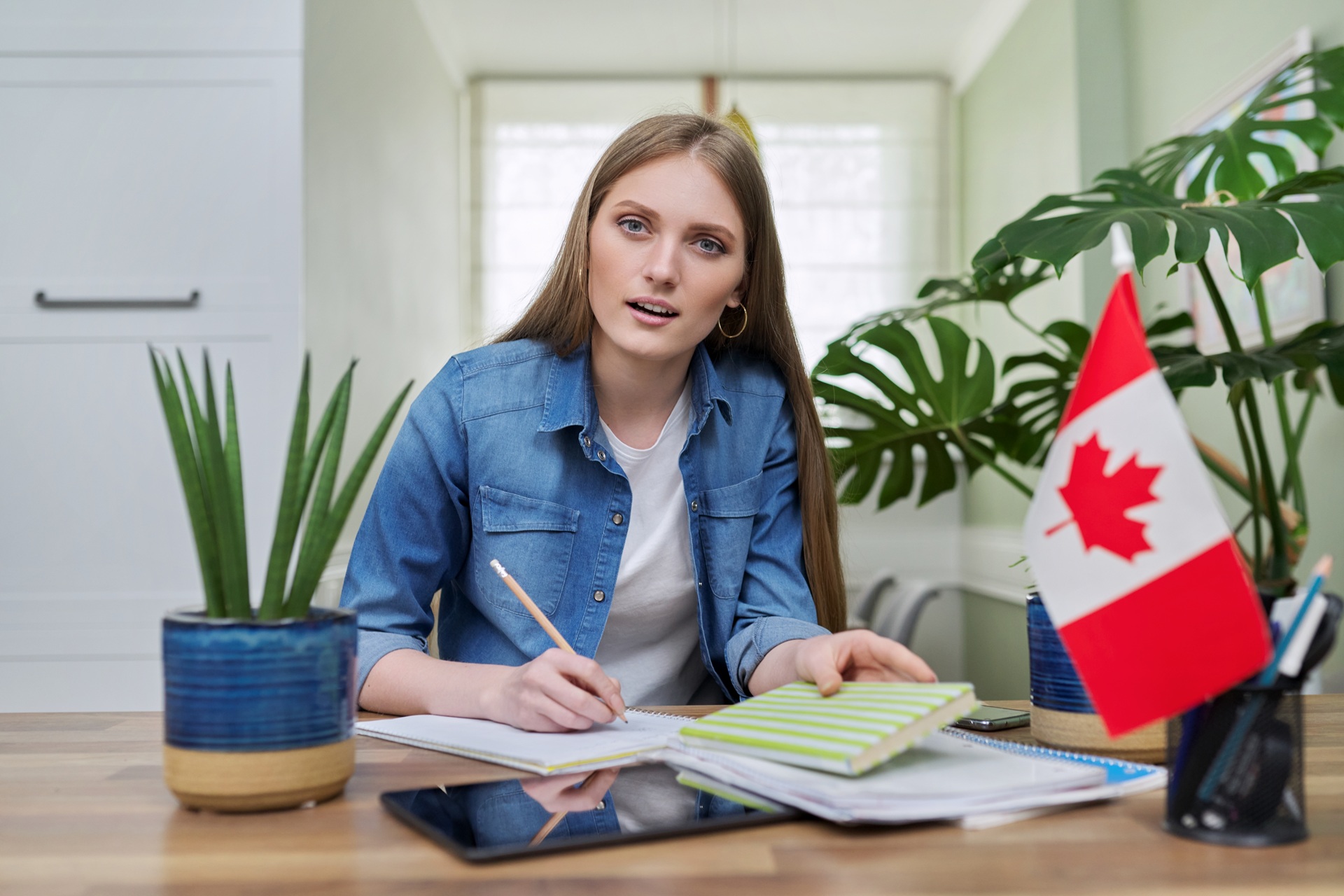 Young woman studying at desk with Canadian flag