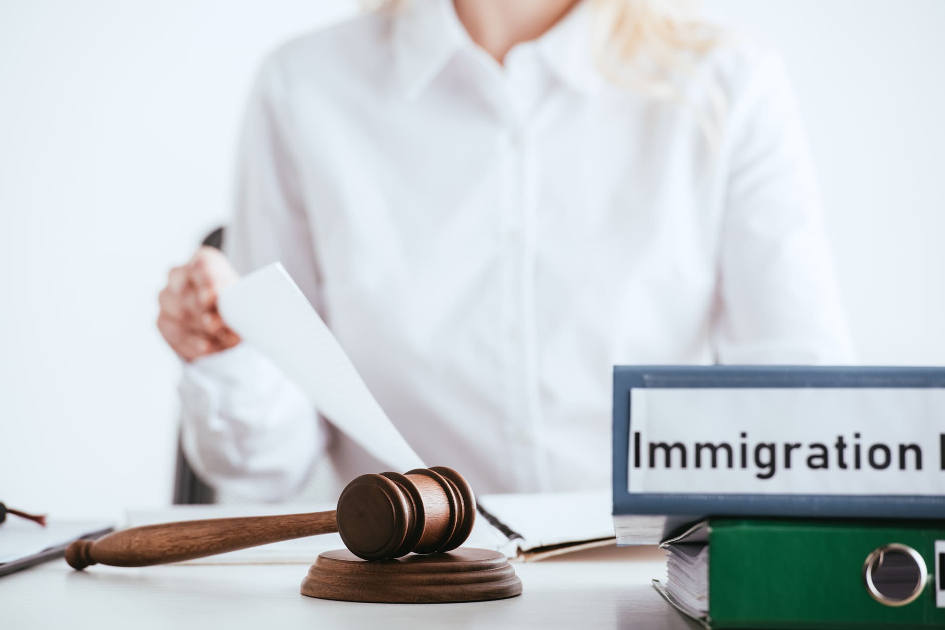 Gavel and immigration law binders on desk