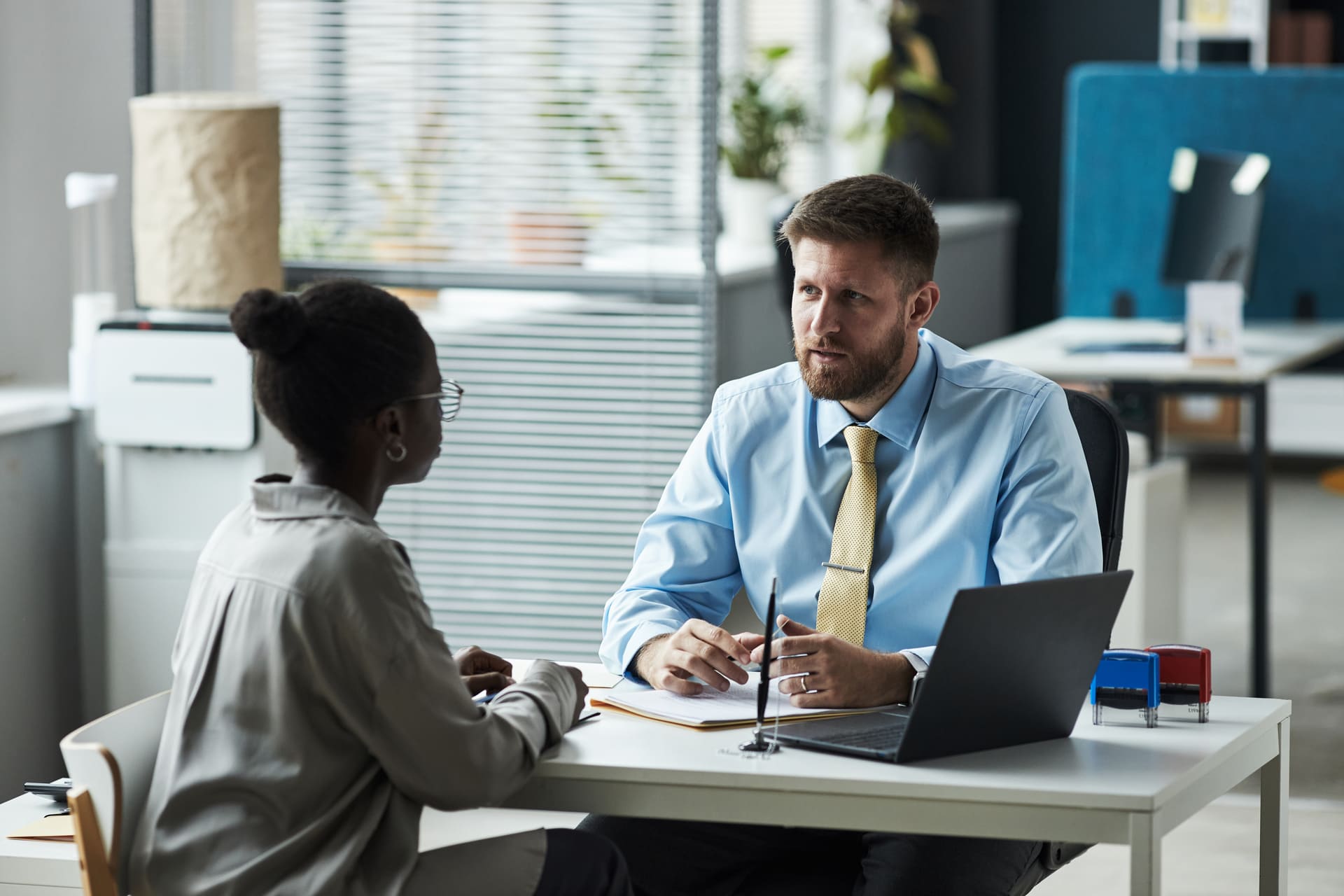 Immigration consultant discussing application with a client in an office
