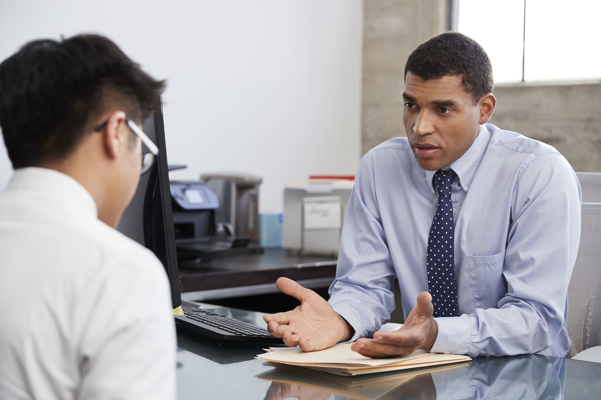 Immigration consultant talking with a client in an office setting