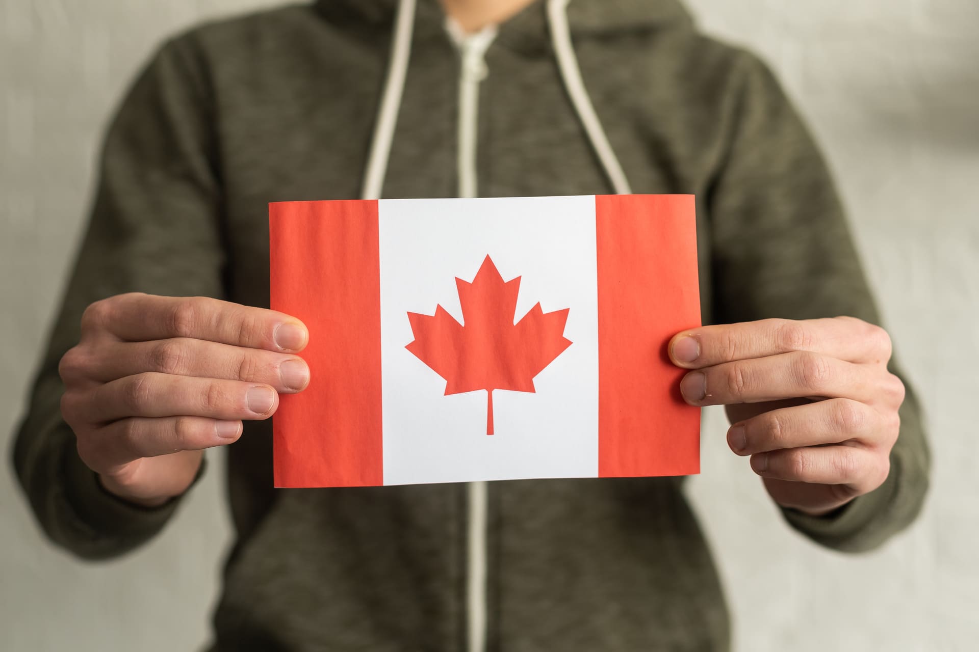Person holding a Canadian flag in both hands