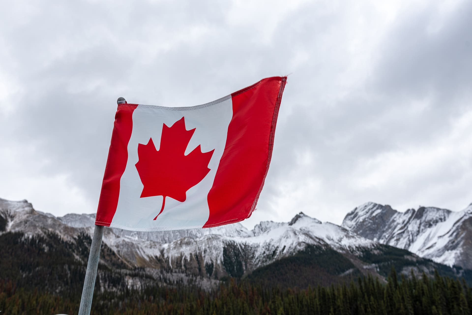 Canadian flag waving with snowy mountain background