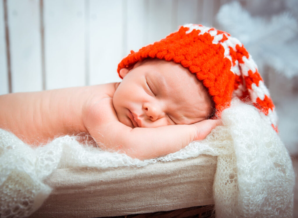 Newborn baby in Santa hat with canadian colors