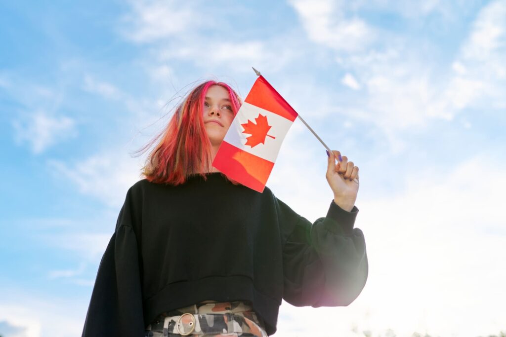 Young female student waving small canadian flag