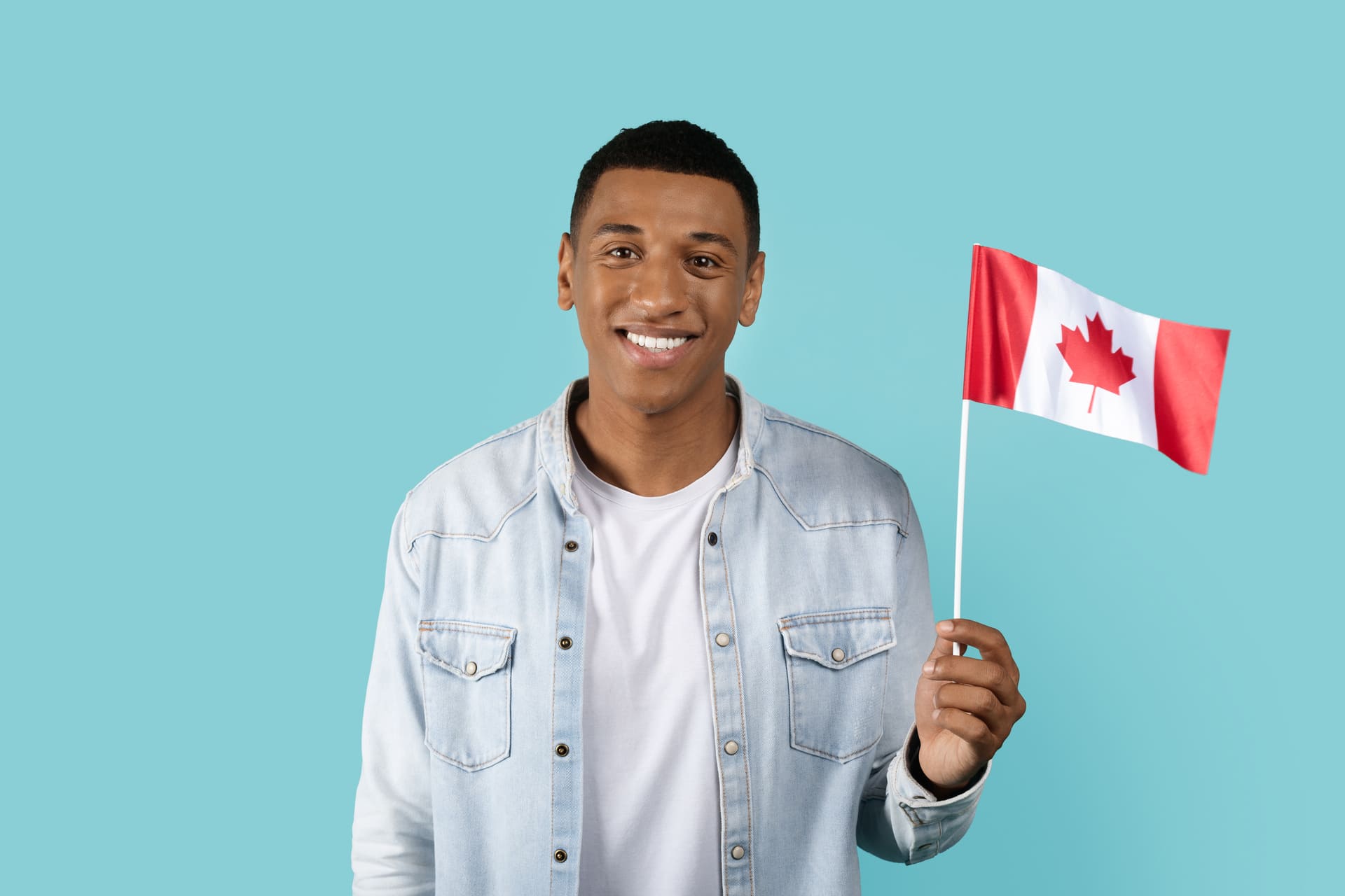 Happy young african man with canadian flag