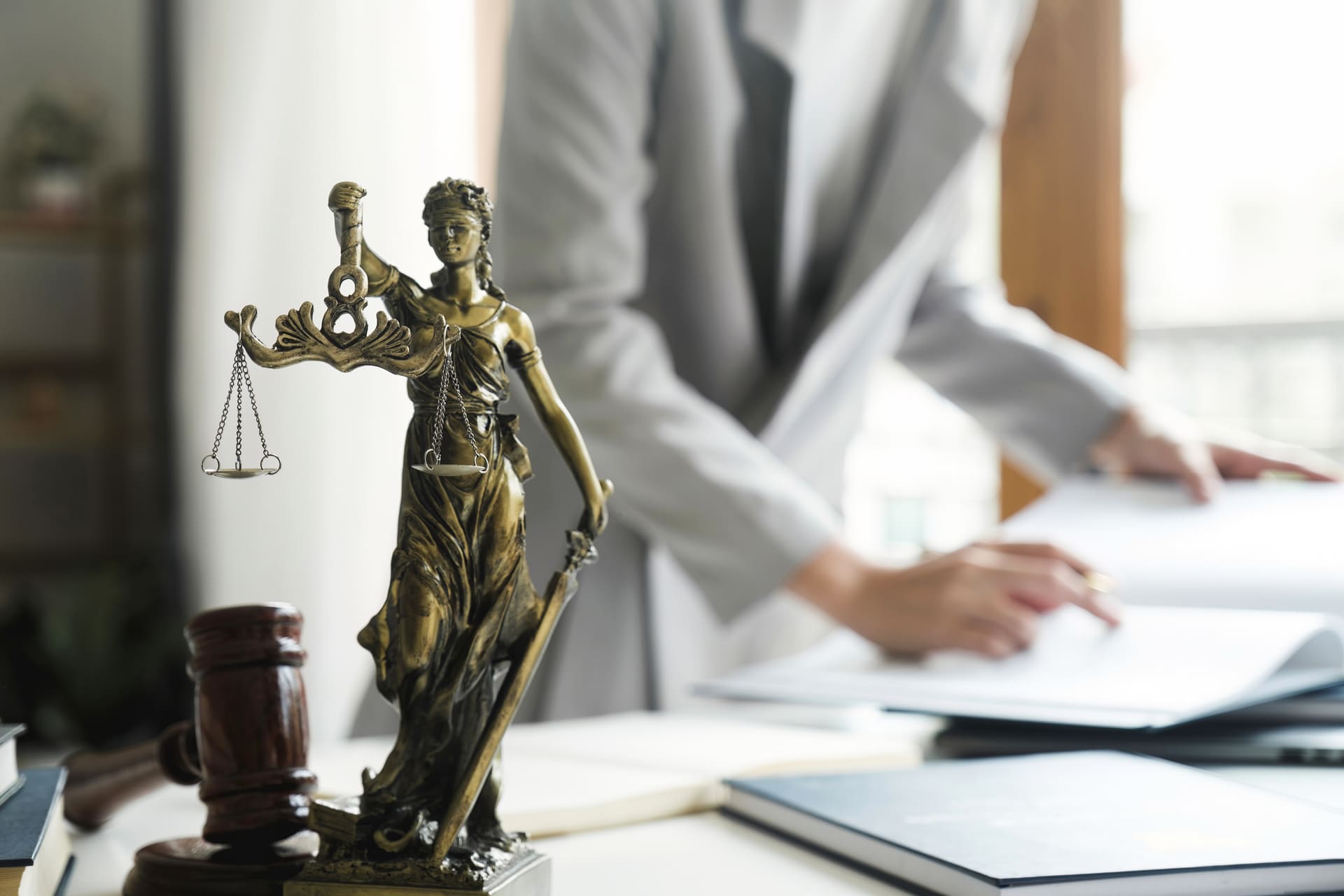 female lawyer working behind statue of lady justice