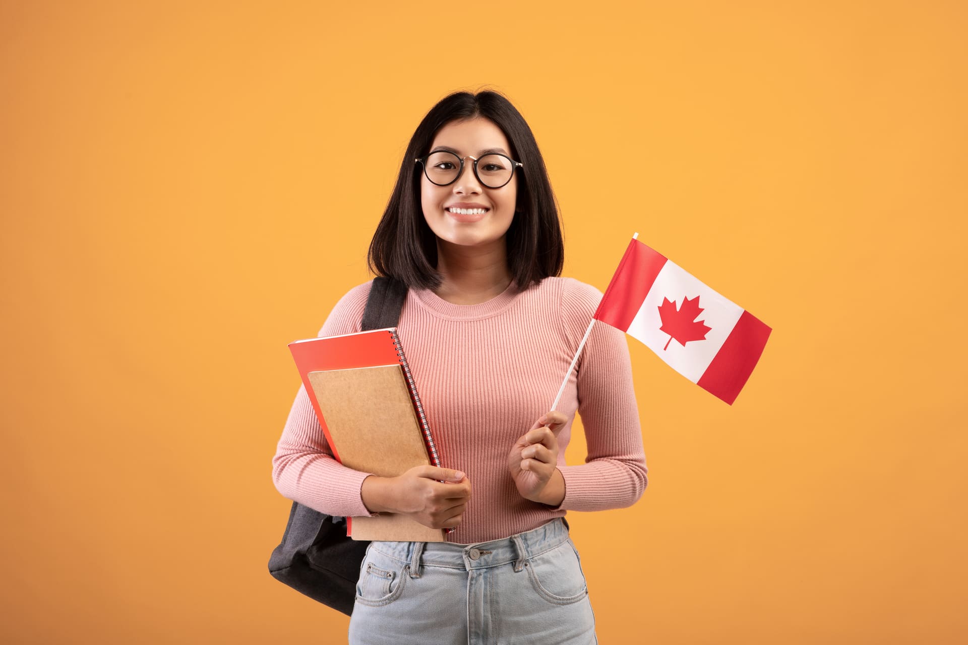 smiling-woman-holding-a-canadian-flag-and-books