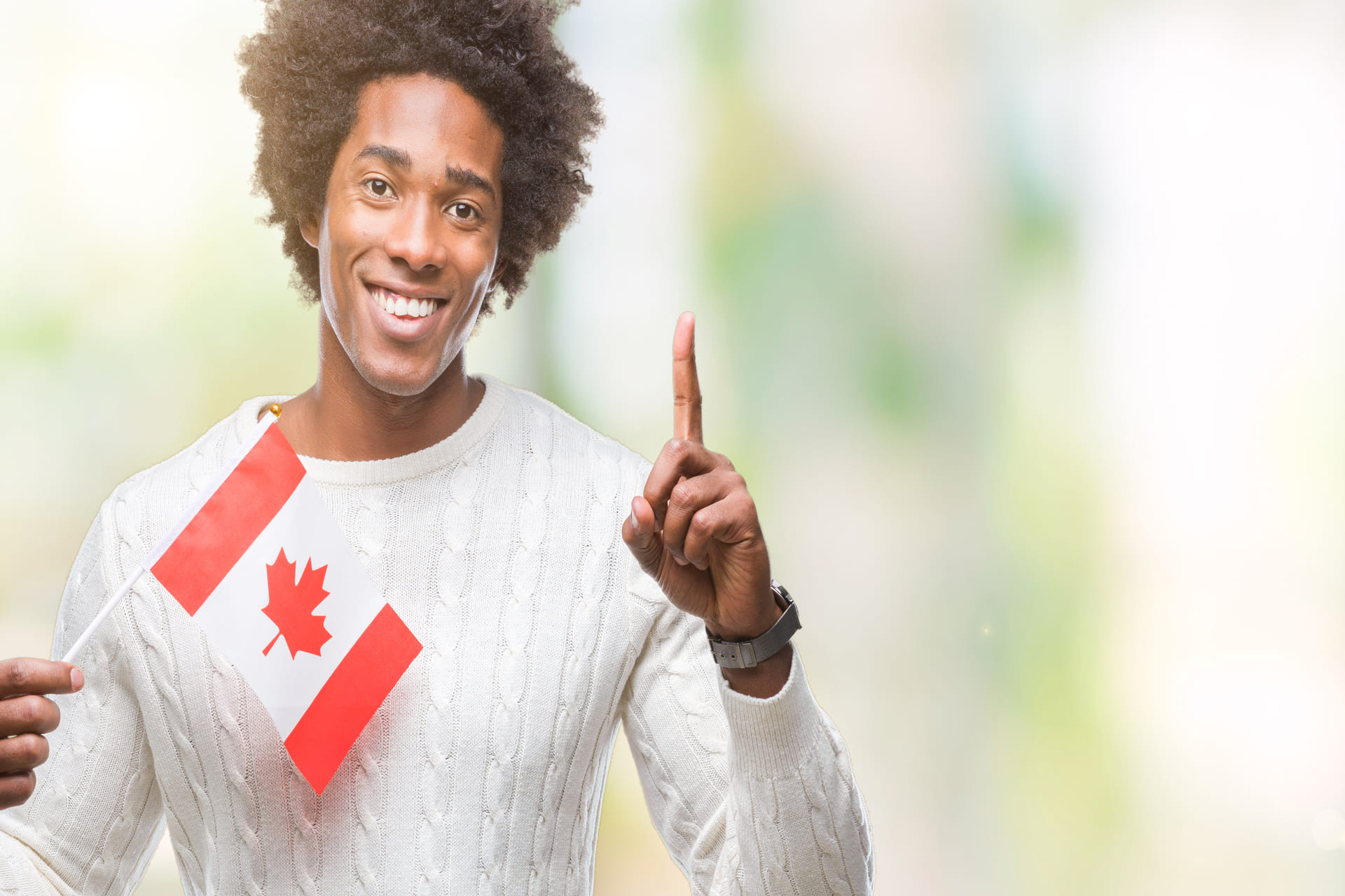 smiling-man-holds-canadian-flag-pointing-upward