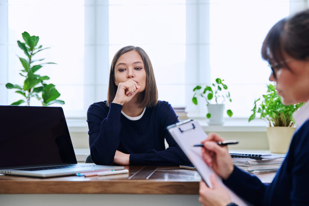thoughtful-woman-interviewed-at-workplace-with-laptop