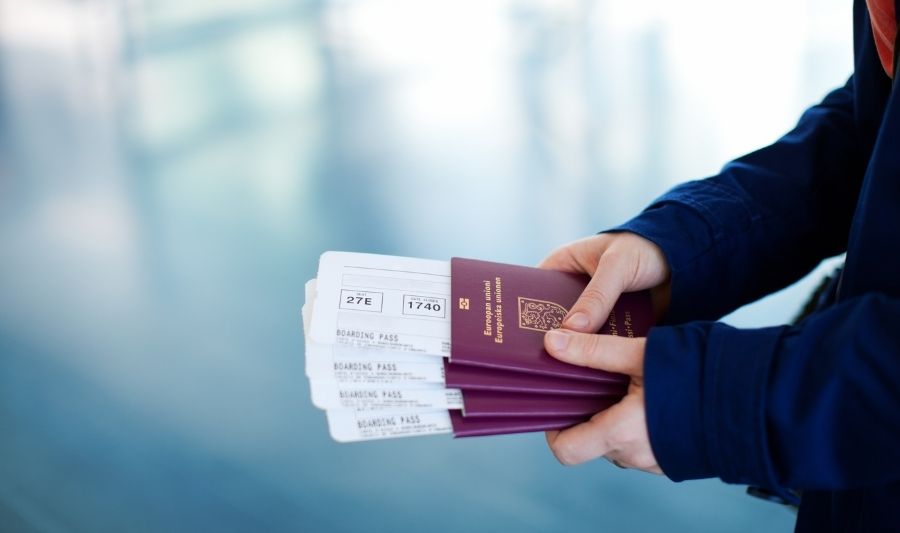 woman holding a stacked passports and flight tickets