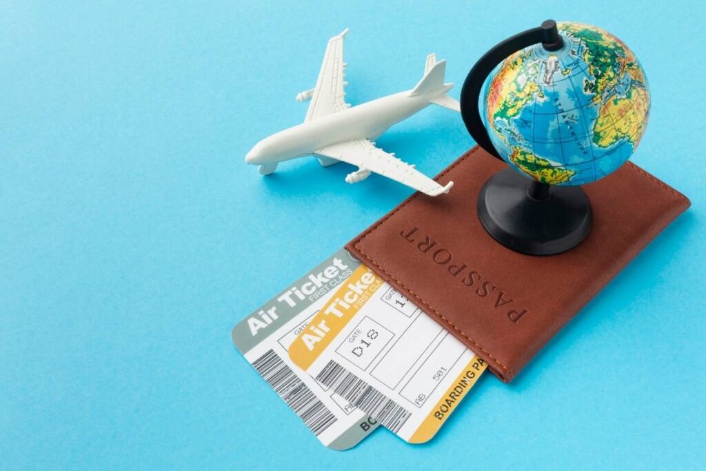 passport and plane ticket in the table with small globe and model plane